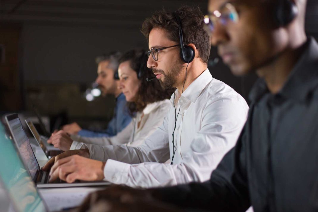 Side view of confident call center operator talking with client business voice service